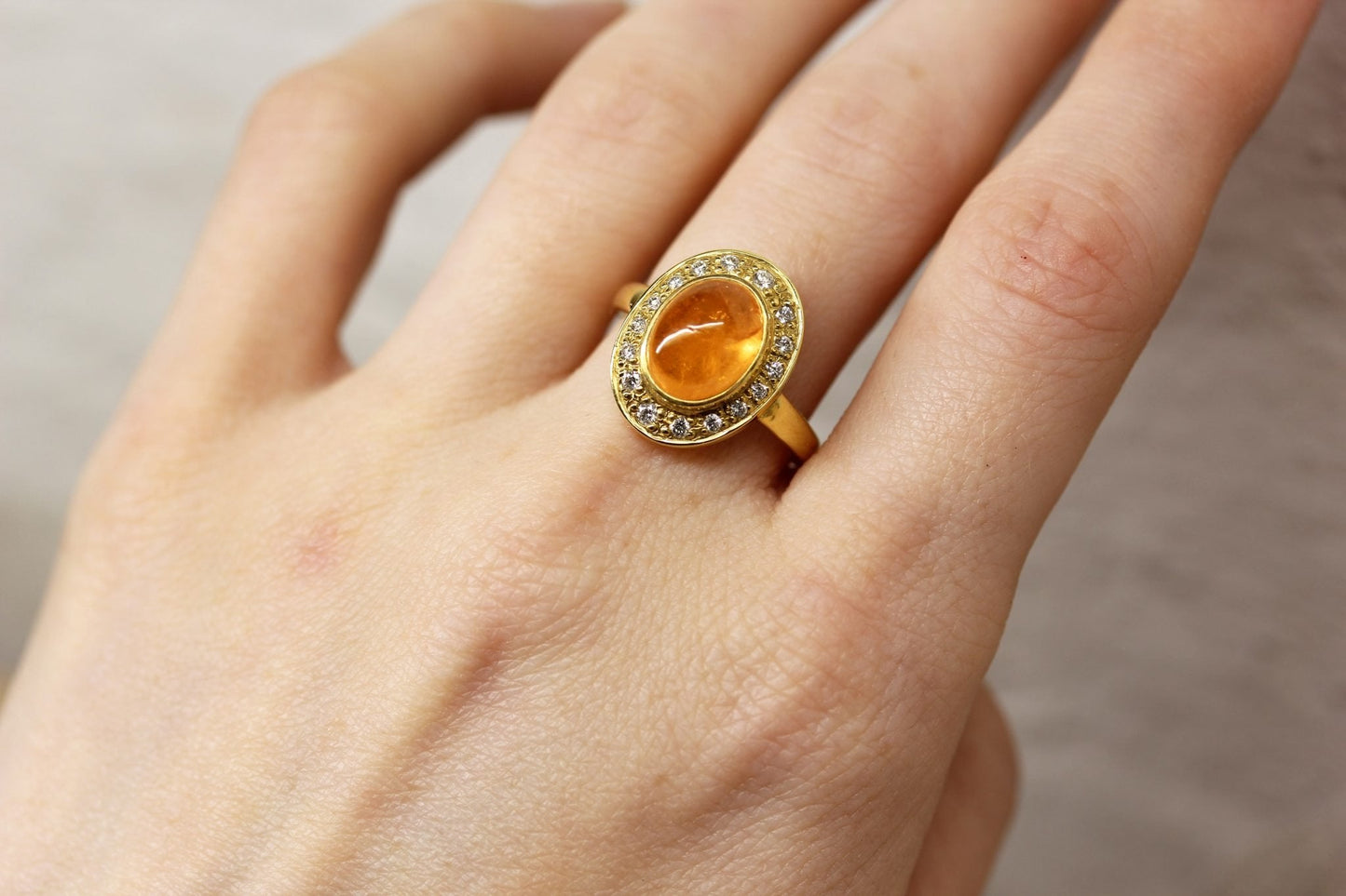 MANDARIN GARNET WITH HALO OF DIAMONDS SET IN 18CT YELLOW GOLD